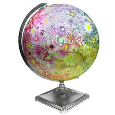 an artistically painted globe sits on a metal stand, with flowers all over it