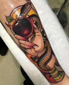 a person with a snake and apple tattoo on their arm