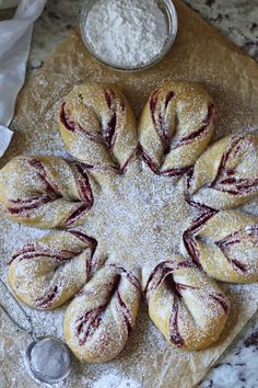 several pastries sitting on top of a table covered in powdered sugar