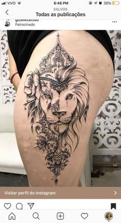 the back of a woman's thigh with a lion tattoo on it and flowers