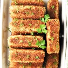 several pieces of bread with herbs on top in a white dish, ready to be eaten