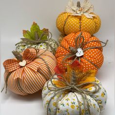 four decorative pumpkins sitting on top of each other in different colors and patterns,