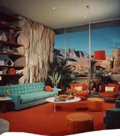 a living room filled with lots of furniture and walls covered in desert scenes, including mountains