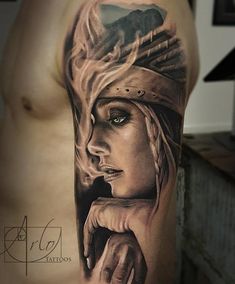 a man's arm with a tattoo on it that has an image of a woman holding