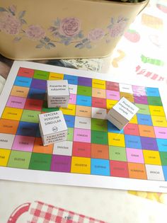 a board game with three dices sitting on top of it next to a potted plant