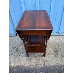 a small wooden table with one drawer on the top and two drawers on the bottom