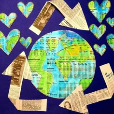 the earth is surrounded by many pieces of paper and cut out heart shaped shapes with words written on them