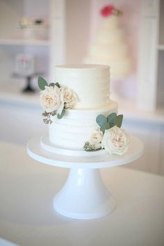 a three tiered cake with white flowers on top