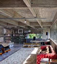 a living room filled with lots of furniture and bookshelves next to a window