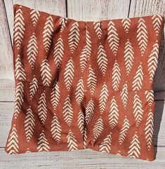 an orange and white pillow sitting on top of a wooden floor