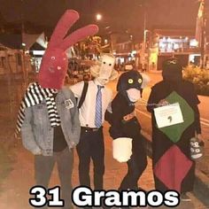 three people in costumes standing next to each other on the sidewalk with one person wearing a bunny mask