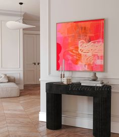 a painting is hanging on the wall above a console table in a living room with hardwood floors