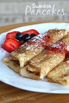 crepes with powdered sugar and strawberries on a plate