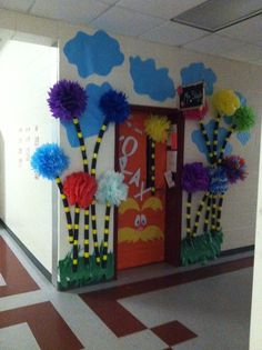 a hallway decorated with paper flowers and decorations for the door to an office building or school