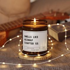 a candle sitting on top of a table next to a string of lights and a guitar