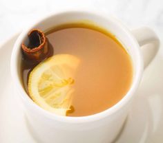 a cup of tea with lemon and cinnamon in it