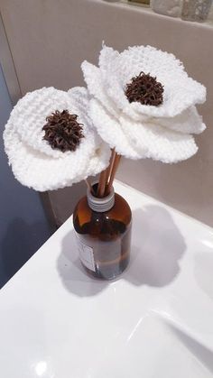 two white flowers are in a brown bottle