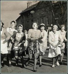 an old black and white photo of women walking down the street