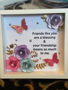 a white frame with some paper flowers and butterflies on it that says friends like you are a blessing & your friend means so much to me