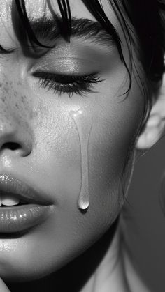 a black and white photo of a woman with tears on her face