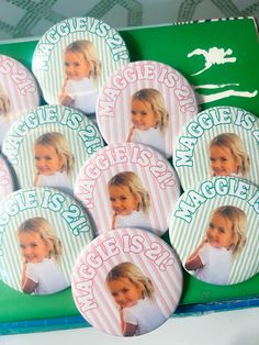 a bunch of badges with pictures of children's faces on them in pink and green