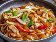 a bowl filled with chicken and vegetables on top of a table