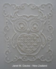 an owl is shown in the middle of a white piece of paper with lacework on it