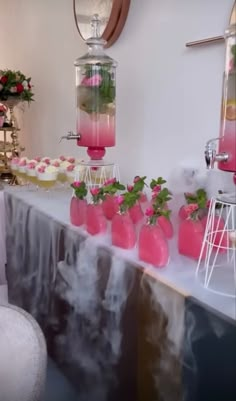 a table topped with pink vases filled with plants