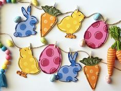 colorful felt easter bunnies and carrots hanging from string on white surface with beads