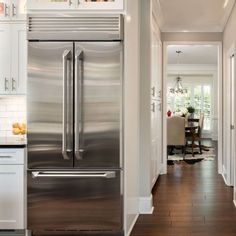 a stainless steel refrigerator in a white kitchen