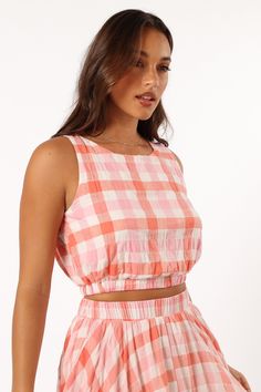 DETAILS   Our Betty Top is the perfect go-to for any sunny day. It features a cropped length, non adjustable straps and an elasticised waistband to keep you stylish and comfortable all day long. With a pink gingham print design to make you stand out from the crowd.   cropped length  round neckline  non adjustable straps  elasticised waistband  gingham print  lined  m aterial - 100% cotton / lining - 100% rayon     SIZING      studio model is 5' 7" and wears a Size S    model stats: bust - 33", w Pink Cropped Top For Vacation, Summer Picnic Crop Top, Spring Crop Top For Picnic, Spring Picnic Cropped Top, Casual Gingham Cotton Crop Top, Pink Crop Top For Summer Day Out, Casual Gingham Crop Top For Spring, Sleeveless Crop Top With Elastic Waistband For Spring, Plaid Cotton Crop Top For Spring