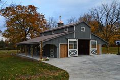 a large gray barn sitting in the middle of a field