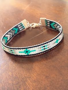 Lovely summer look in this slim beaded ankle bracelet in cool turquoise, black, white and gray. Created with seed beads and silver tone ends. Approximately 1/4 inches in width. Choice of clasp types available. Available in various sizes. Measure ankle in inches for sizing. Bracelet measurements in inches do NOT include closure clasp...measures from end piece to end piece NOTE:  These are well made bracelets.  However, as with any jewelry piece, they are not indestructible 😊.   When putting on, wearing, or removing bracelet, please refrain from pulling on the beaded portion of the bracelet.  Hold and close or open by the clasp only,  This will protect the bracelet from separating from the end pieces.  Again these bracelets are well made but if handled incorrectly or pulled too strongly the Made Bracelets, Bracelet Measurements, Bracelet Loom, Loom Designs, Bead Loom Designs, Beaded Ankle, Loom Bracelet Patterns, Loom Bracelet, Wrap Bracelets