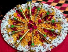 a plate with gold and red confetti arranged in the middle on a table