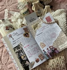 an open book sitting on top of a bed next to a teddy bear and other items