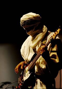 a man with a bandana playing a guitar