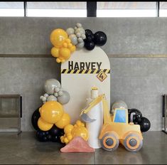 a construction themed birthday party with balloons and decorations on the wall, including an excavator