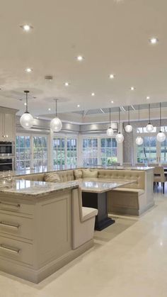 a large kitchen with an island in the middle and lots of lights hanging from the ceiling