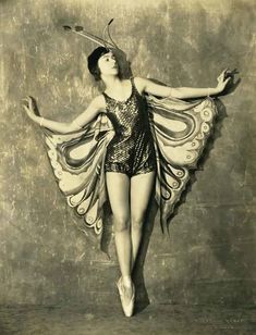 an old photo of a woman wearing a costume