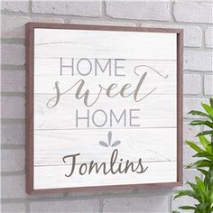 a wooden sign that says home sweet home tonilis hanging on a brick wall