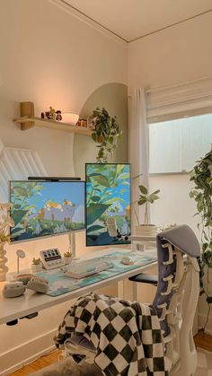 two computer monitors sitting on top of a desk next to each other in front of a window