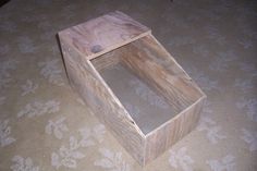 a wooden box sitting on top of a carpeted floor