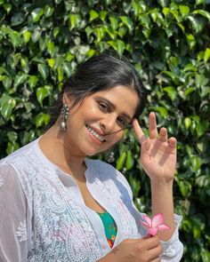 a woman is making the peace sign with her hand