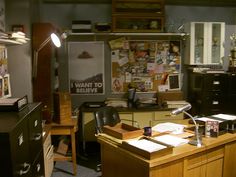 an office with a desk, chair and lamp in the corner is cluttered with papers