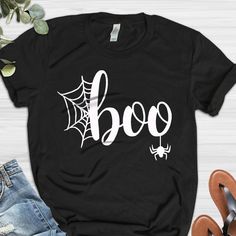 a black t - shirt with the word boo on it and spider web in white