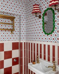 a bathroom with red and white tiles on the walls