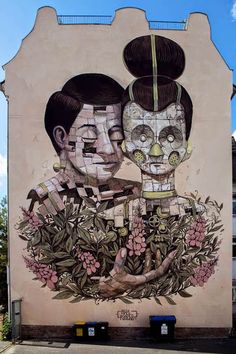 a large mural on the side of a building with two people holding each other's head