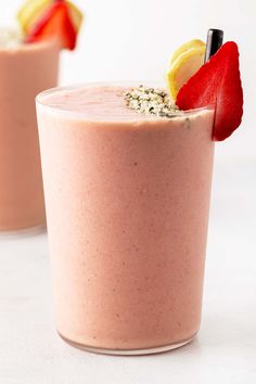 two glasses filled with smoothie and strawberries