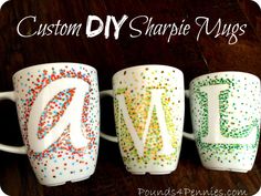 three coffee mugs with letters painted on them