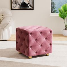 a pink ottoman sitting on top of a white rug next to a potted plant